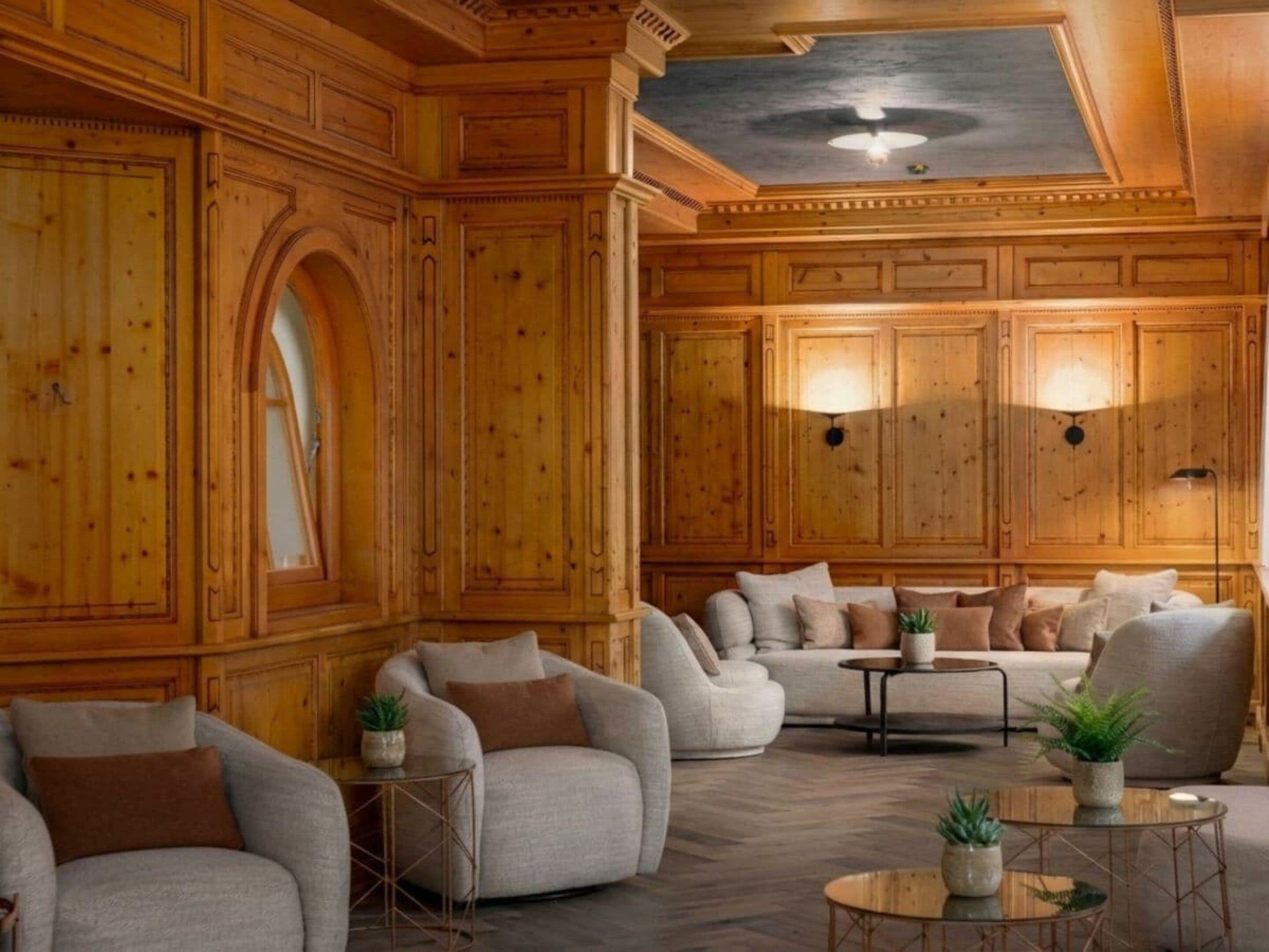 Ein geräumiger Raum mit Holzwänden, einem großen Rundbogen und einer Sitzecke mit Sofas und einem Couchtisch.