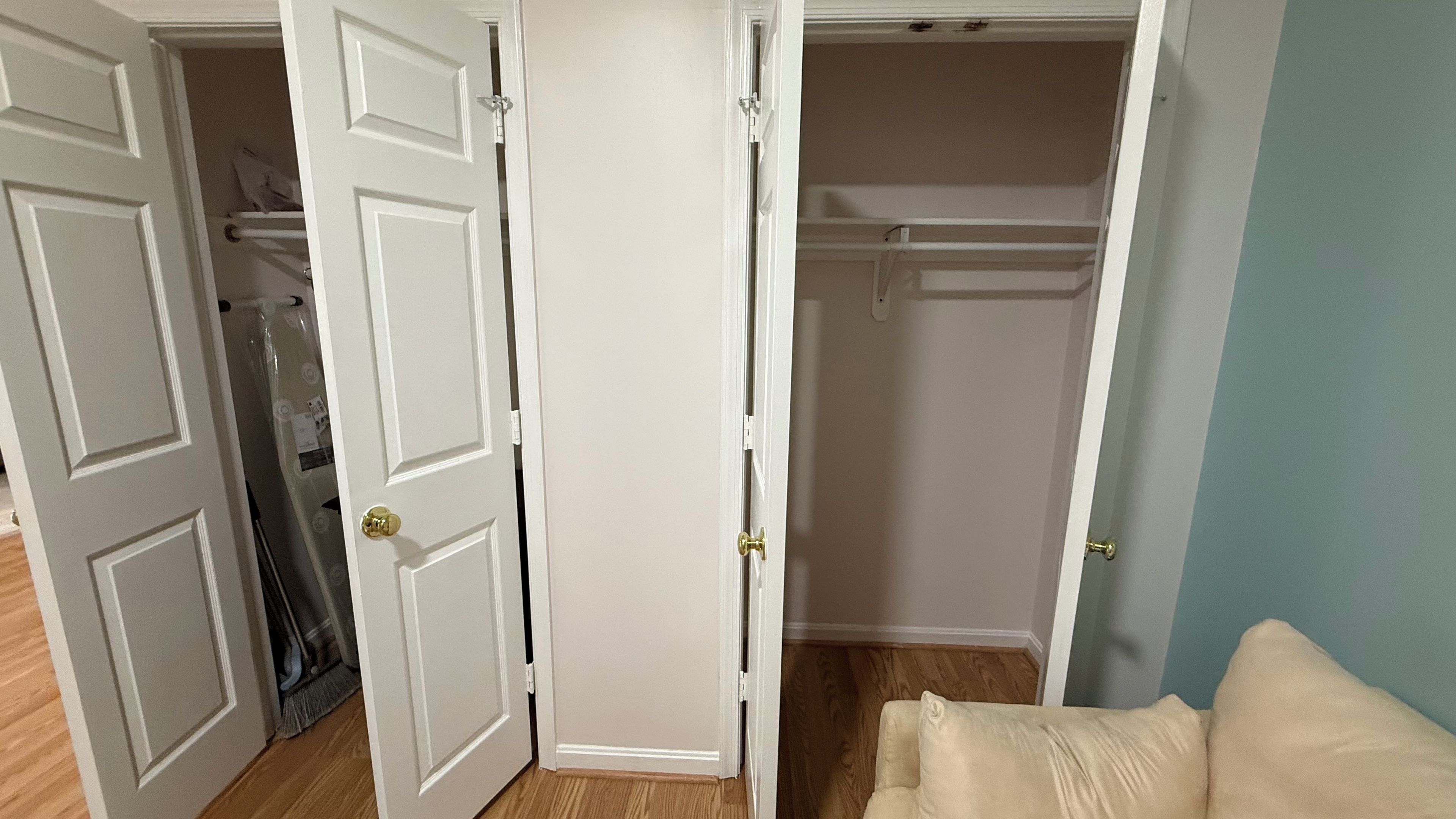 A room with a closet, a door, and a light-colored wall.