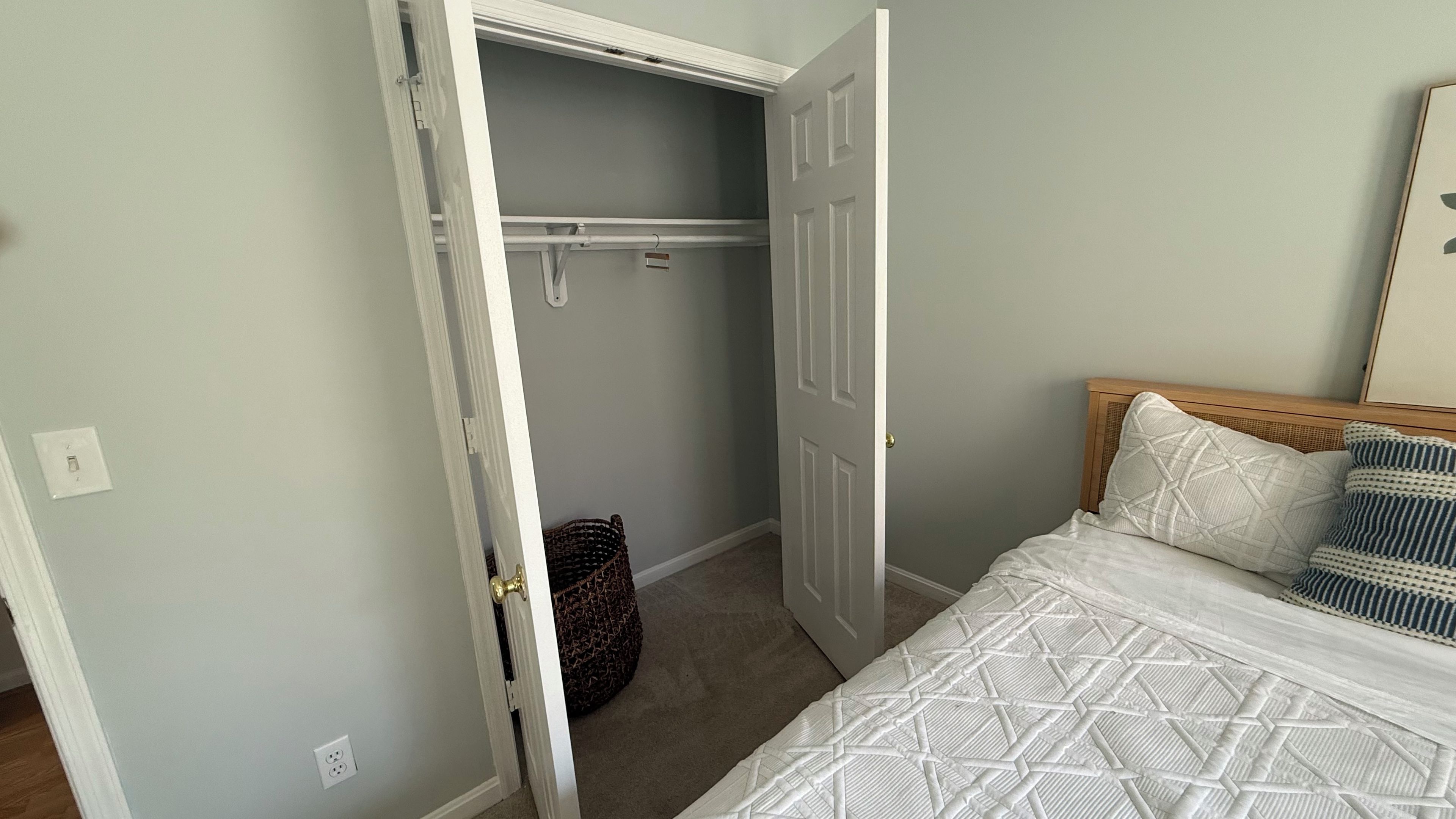 A bedroom with a bed, a closet, and a door leading to a bathroom.