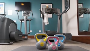 A gym with exercise equipment including a treadmill, elliptical, and kettlebells. - Newcastle SuperKing Studio Suite | Free Breakfast! (Newcastle Upon Tyne)