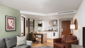 Ein modernes Wohnzimmer mit einem grauen Sofa, einem braunen Sessel und einem Couchtisch.