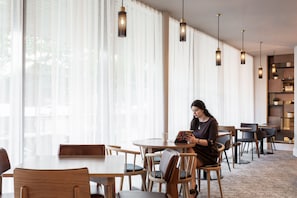 A modern interior with large windows, wooden furniture, and pendant lighting.