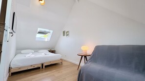 A bedroom with a bed, a window, a lamp, and a couch. - Charming 2-bedroom house in the Baie de Somme (Noyelles-sur-Mer)