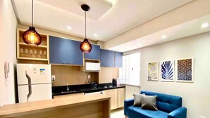 A modern kitchen with a wooden island, blue cabinets, and pendant lighting. - 302 - 2 Bedrooms Charming (Belém)