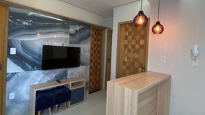 A modern kitchen with a central island, a built-in TV, and pendant lighting. - 302 - 2 Bedrooms Charming (Belém)
