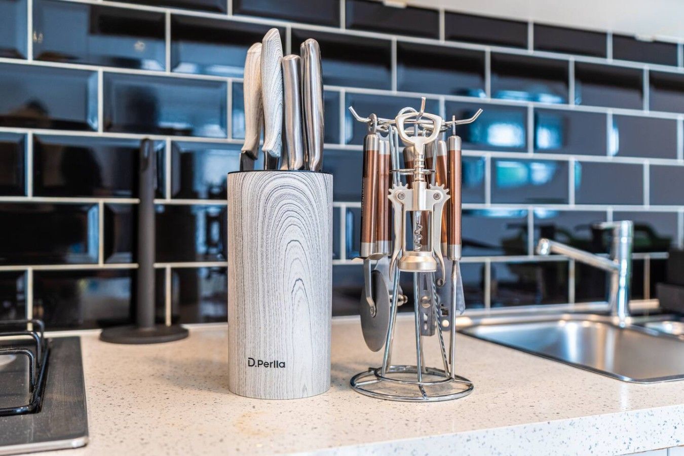 A kitchen counter with a knife holder and a metal utensil holder.