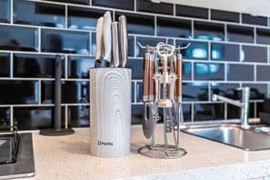 A kitchen counter with a knife holder and a metal utensil holder. - Cosy 1BR Flat | West Kensington | Sleeps 5 |London (Greater London)