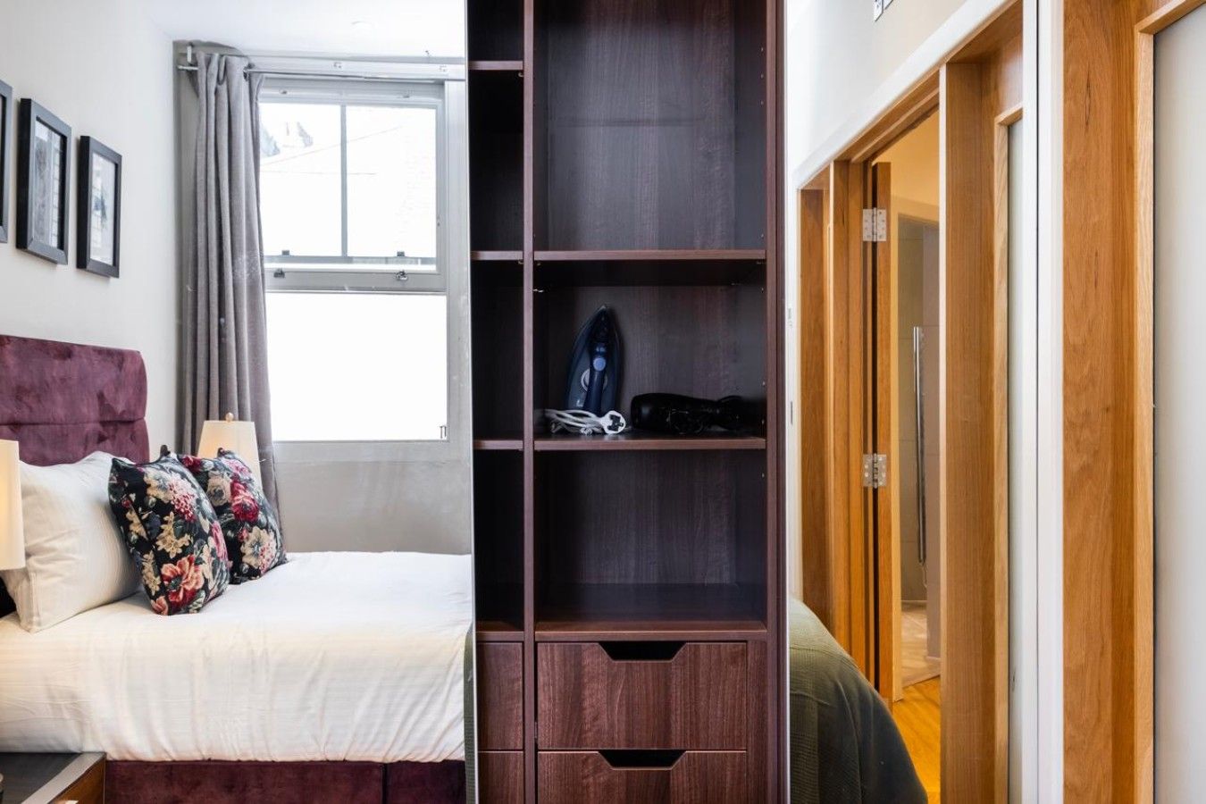 A bedroom with a bed, a wardrobe, and a window.