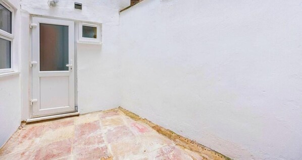 A white-walled room with a tiled floor and a door. - Stylish 3BR | 3 En-Suite Showers | Sleeps 8 (Greater London)