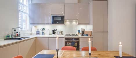 Una cocina moderna con una mesa de comedor, velas y vistas a la ciudad.