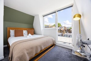 Et hotelværelse med en seng, et stort vindue og en gulvlampe.