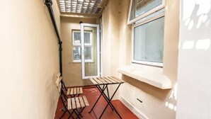 A narrow corridor with a wooden bench, a window with a white sill, and a door leading to another room. - Elegant West Kensington Studio | Central London (Greater London)