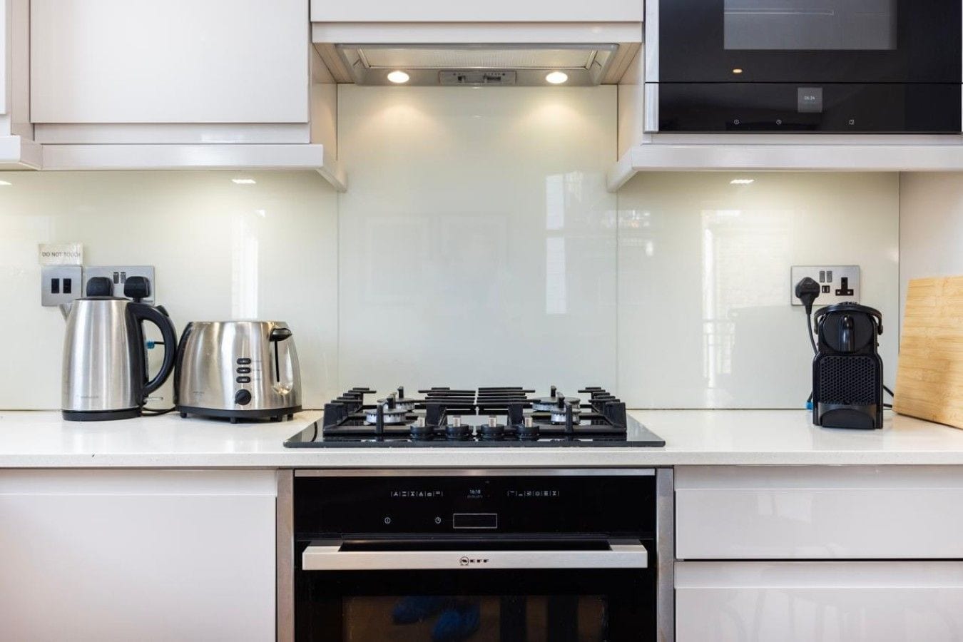 A modern kitchen with a gas stove, a coffee maker, and a dishwasher.
