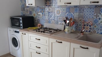Une cuisine équipée d’un lave-linge, d’une cuisinière et d’un évier.