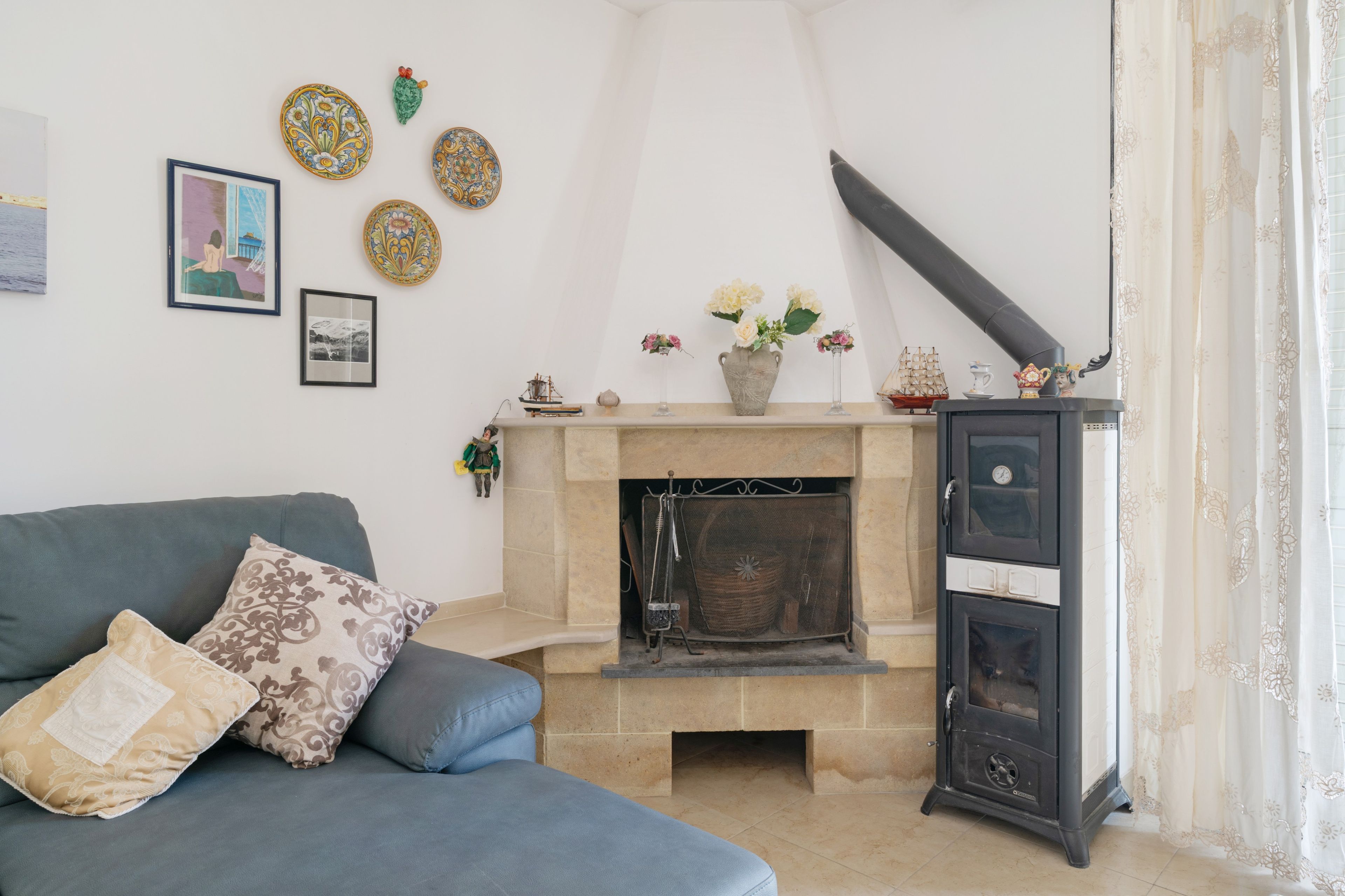 Ein Wohnzimmer mit Kamin, einer Couch und dekorativen Wandbildern.