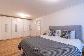 A bedroom with a bed, a wardrobe, and a nightstand. - Historic City of London Gem | 1 Min to Cannon St (Greater London)