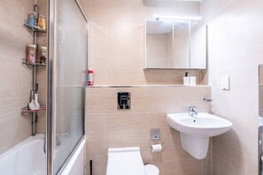 A modern bathroom with a glass shower enclosure, a white sink, and a toilet. - Historic City of London Gem | 1 Min to Cannon St (Greater London)