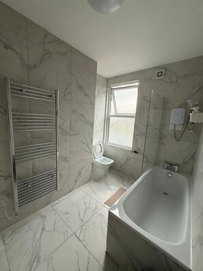 Ein Badezimmer mit Badewanne, Toilette und Dusche.
