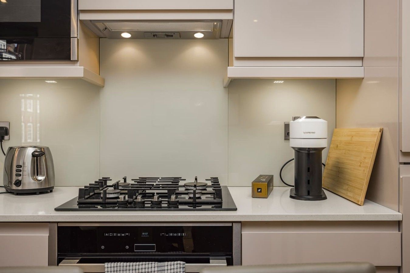 A modern kitchen with a gas stove, a coffee machine, and a toaster.