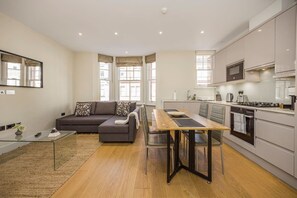 Eine moderne Wohnung mit Wohnbereich, Essplatz und Küche.