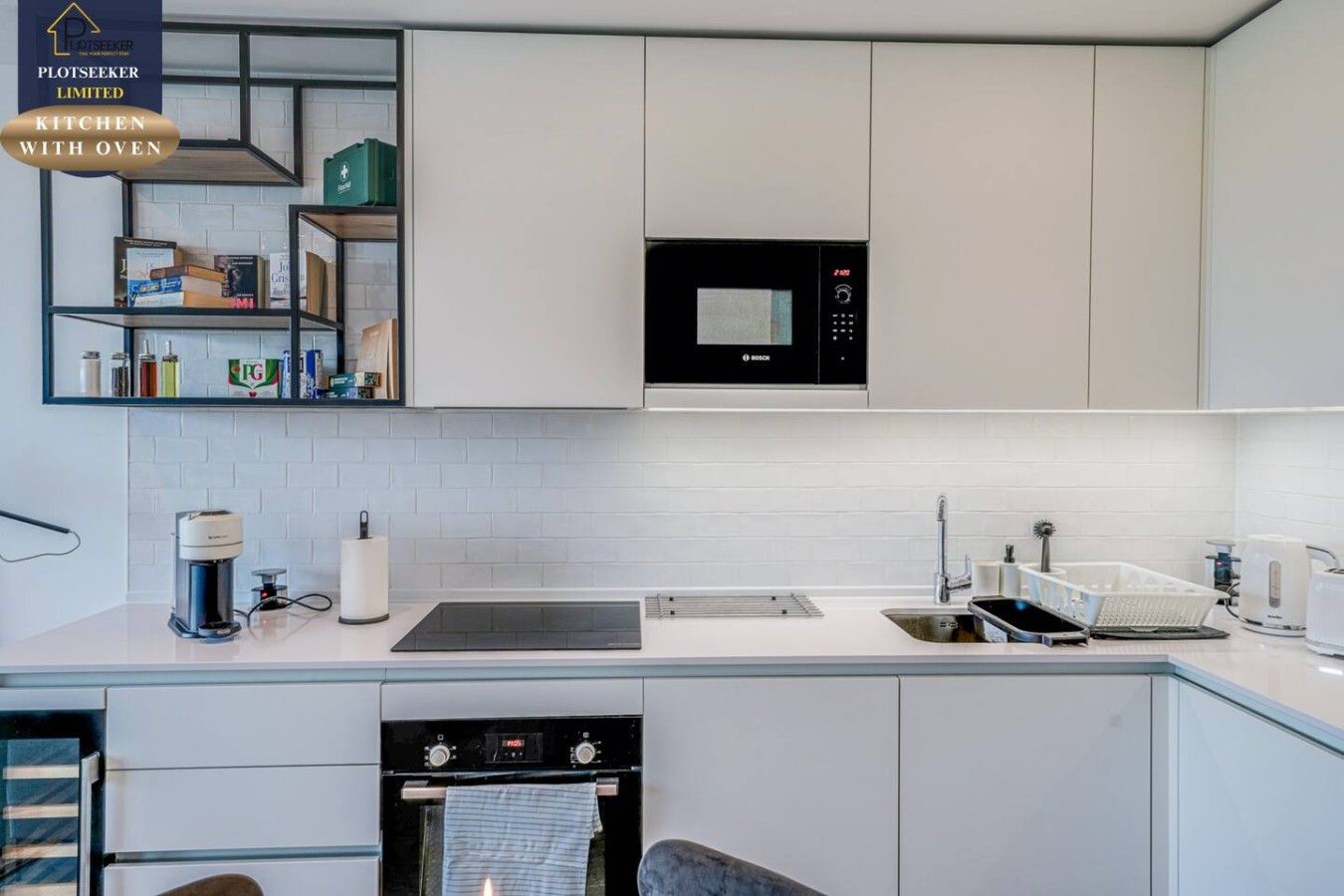 A modern kitchen with a Bosch microwave, a built-in oven, and a sink.