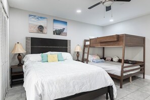 A bedroom with a bunk bed, a single bed, and two bedside tables with lamps. There are two wall-mounted pictures. - Luxury SoCo Oasis, Private Pool, Large Covered Patio & Shuffleboard (Austin)