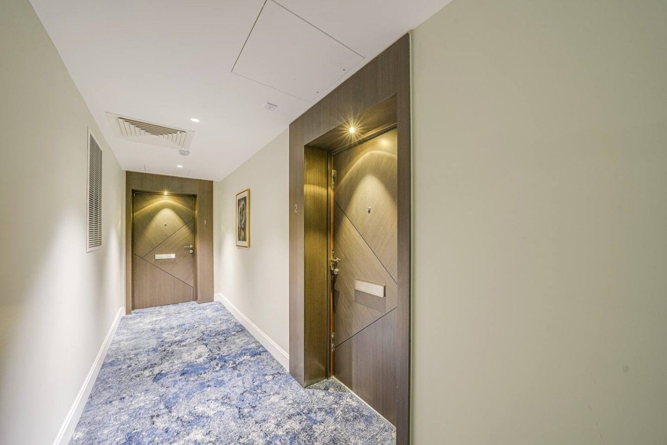 A hallway with two doors, a marble-patterned floor, and a vent on the left wall.