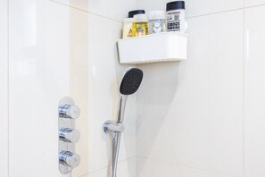 Eine Dusche mit Handbrause und einer fest montierten Bedienung.