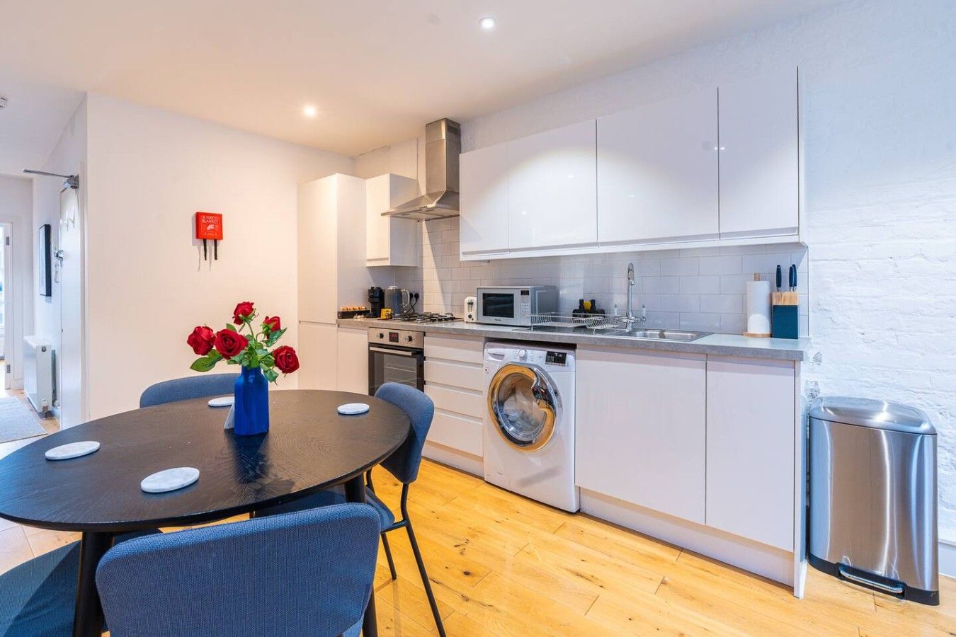 A compact kitchen with a washing machine, a microwave, and a sink.