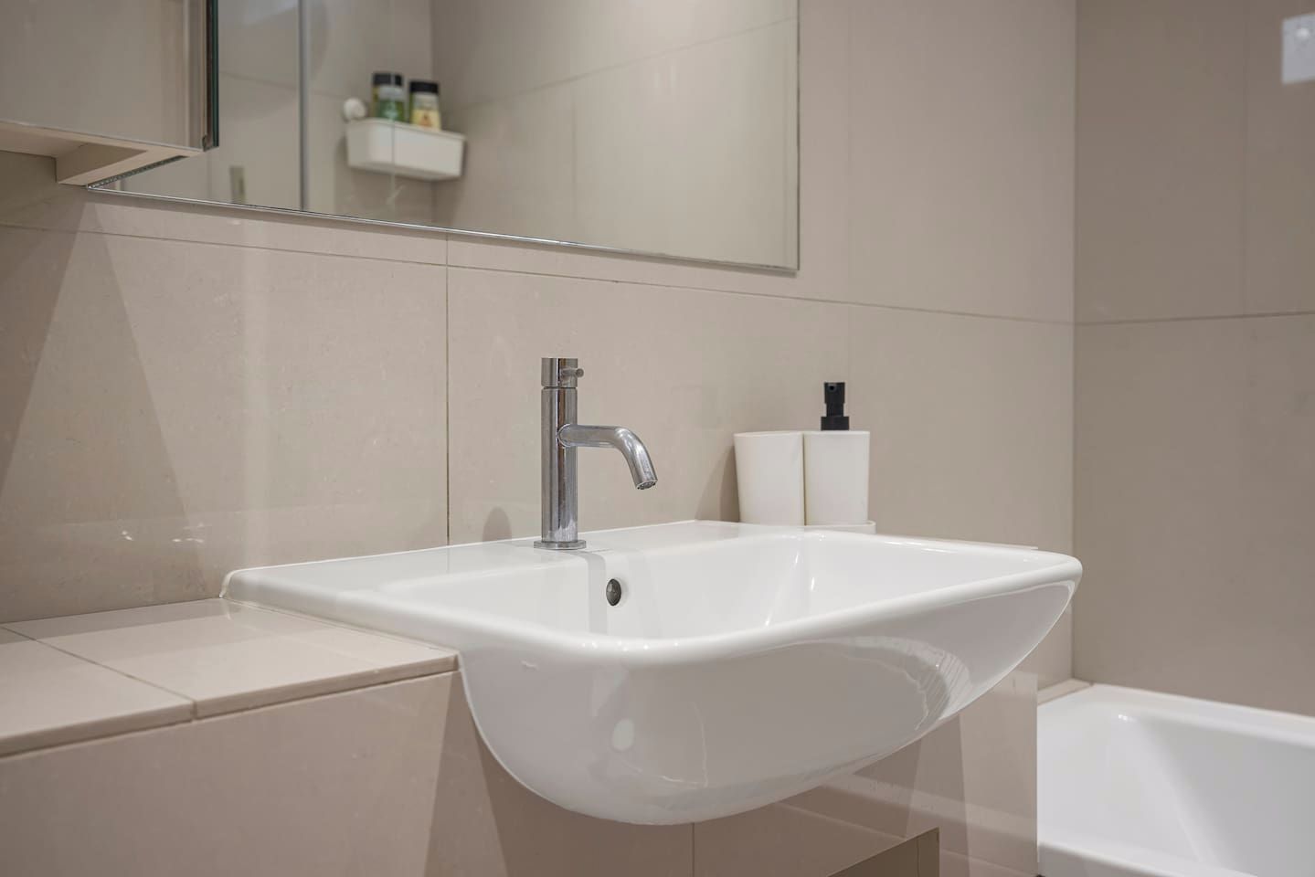 Ein Badezimmer mit einem weißen Waschbecken, einem Spiegel und einer Toilette.