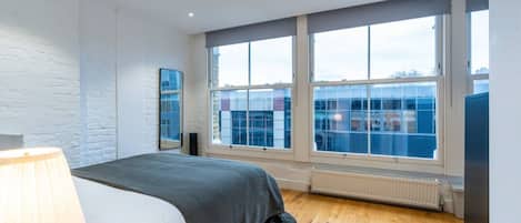 Un dormitorio con cama, ventana y radiador.
