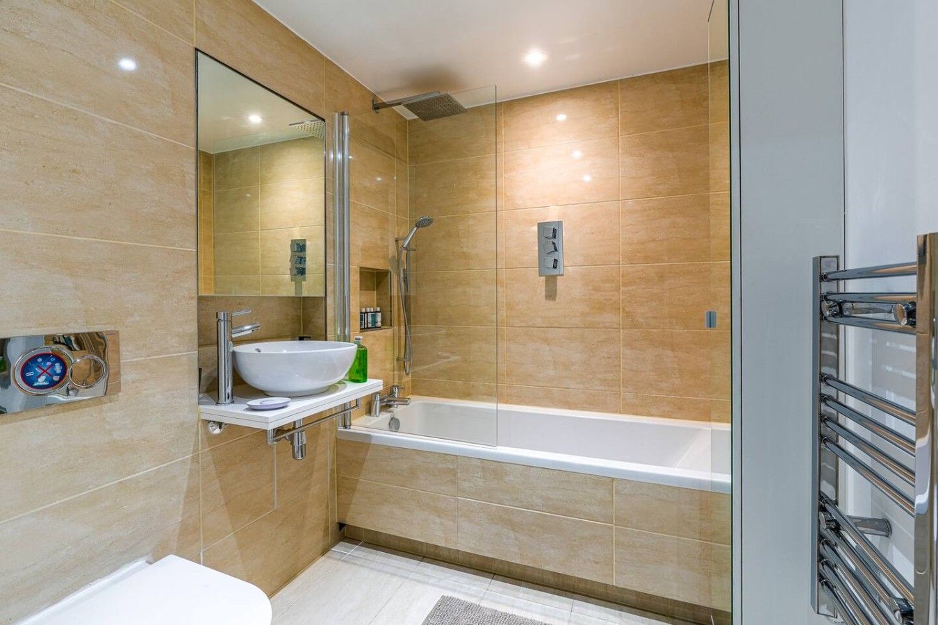 A modern bathroom with a white bathtub, a large mirror, and a sink with a vessel basin.