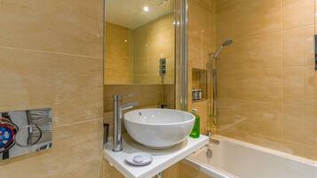 A bathroom with a white sink, a glass shower enclosure, and a bathtub.