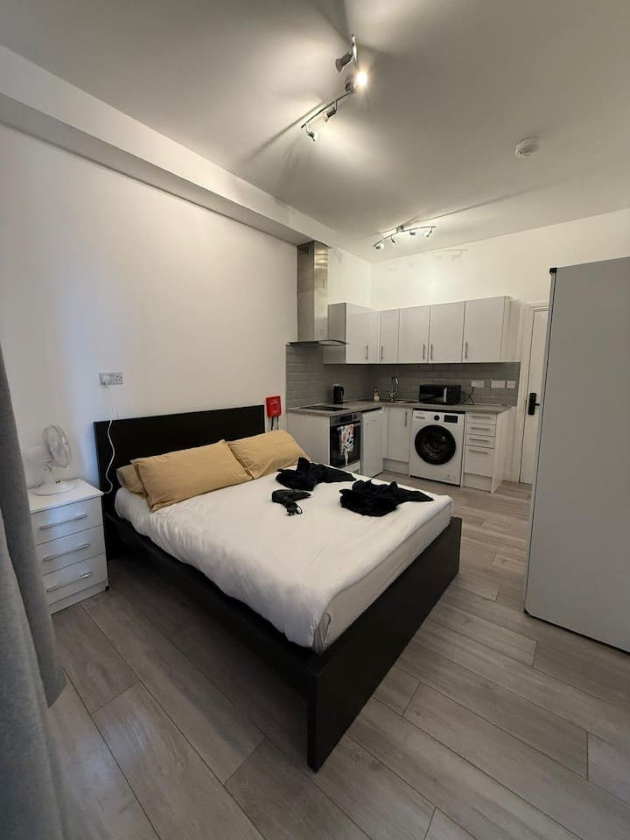 A modern bedroom with a bed, bedside table, and a small desk.