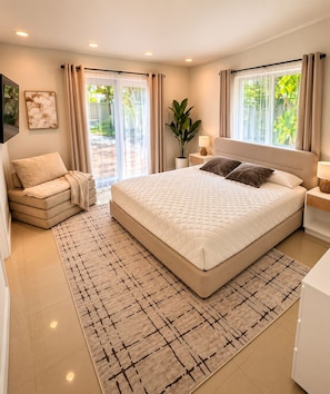 Une chambre moderne avec un grand lit, un canapé et une plante en pot.