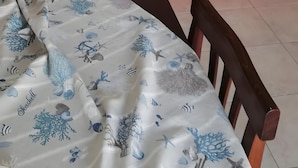 En rød sofa foran en hvid væg med et strandmotiv over.