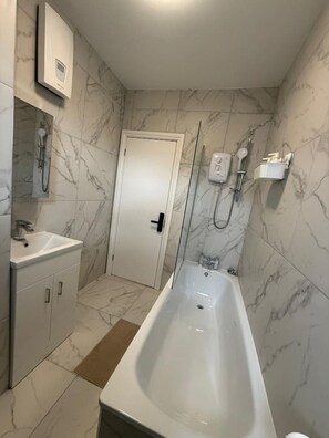 Ein Badezimmer mit Badewanne, Dusche, Toilette und Waschbecken.