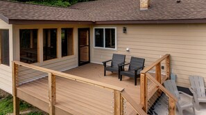 Une terrasse en bois avec des sièges extérieurs et un patio couvert.