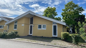 En tvåvåningsbyggnad med ett sadeltak, numrerad 51, med en ytterdörr, fönster och en liten veranda.