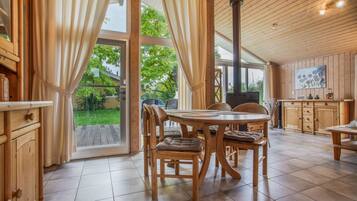 Un interior de madera con una mesa de comedor, sillas y una zona de cocina.
