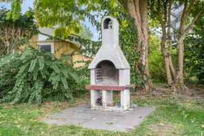 A stone-built outdoor oven structure with a chimney, surrounded by greenery and a paved area. - Favorite Place – the "151-Step House"! (Rechlin)