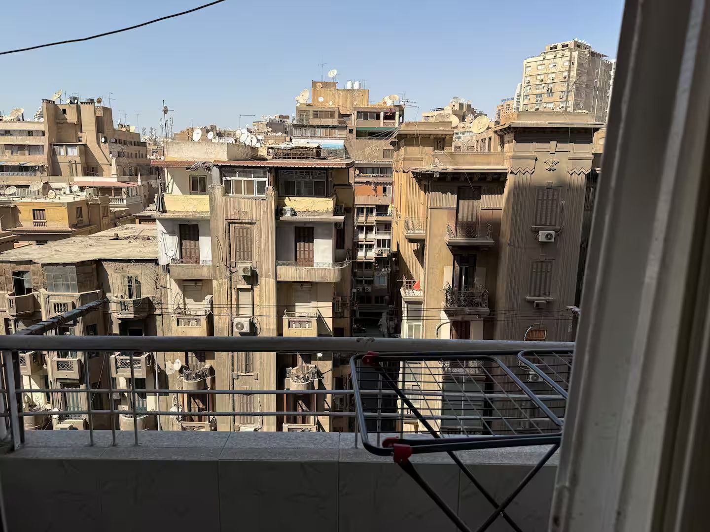 Une vue d’une zone urbaine densément peuplée, avec de nombreux immeubles, dont certains sont dotés de balcons et d’antennes paraboliques.