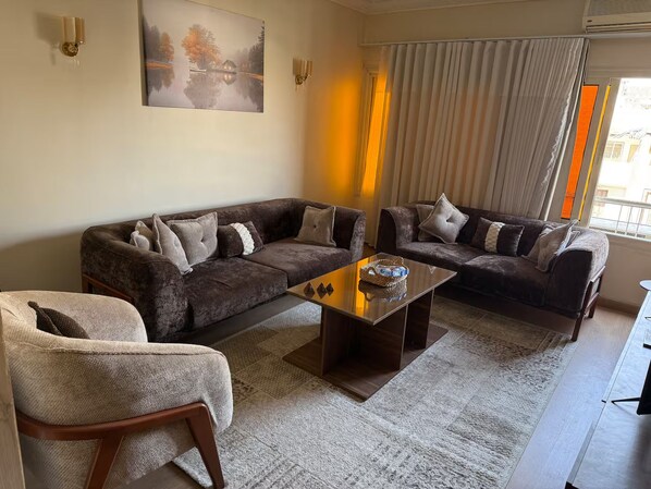 Una sala de estar con un sofá, una mesa de centro y una silla.