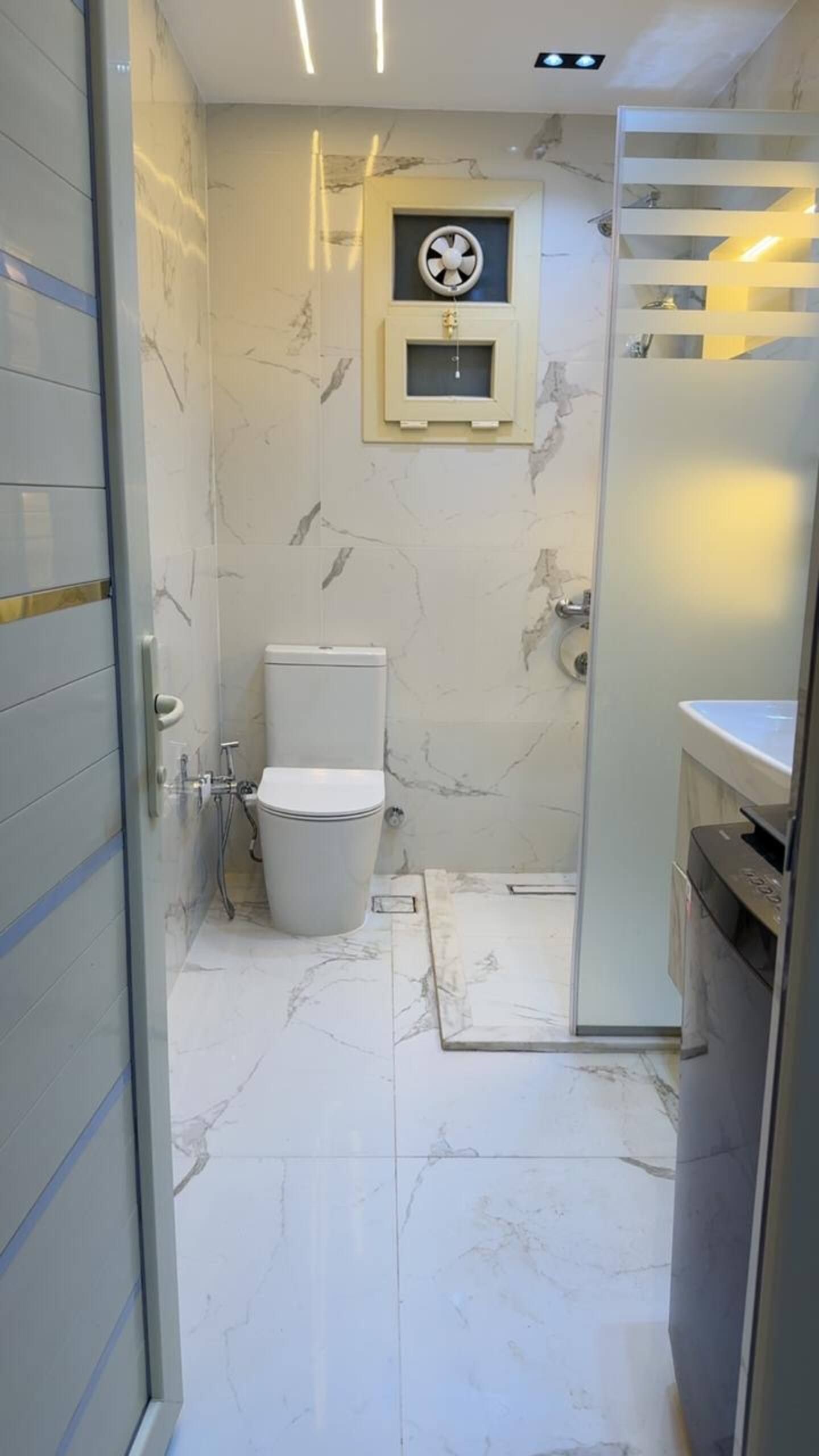 Un bany amb vàter, rentapel i zona de dutxa.