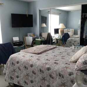 A hotel room with a bed, a desk, a chair, a television, and a mirror. - Cozy 1-bedroom apartment in fabulous Bonita Shores, Bonita Springs 1 mi to beach (Bonita Springs)