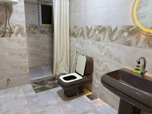 A bathroom with a toilet, sink, and shower area. - Apartment in quiet neighborhood in Dokki (Giza Governorate)