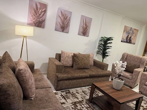 Ein Wohnzimmer mit einer Sofagarnitur, einem Couchtisch und Wanddekoration.
