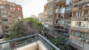 Ein mehrgeschossiges Wohngebäude mit Balkonen, Klimaanlagen und einer darunterliegenden Straße.