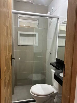 A bathroom with a glass-enclosed shower, a white toilet, and a black sink. - 303 2-bedroom apartment 15 min center (Belém)