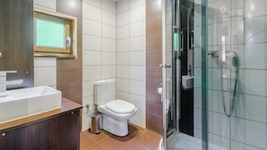 Une salle de bain moderne avec une douche à parois de verre, des toilettes et un lavabo.